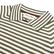 Folded green and white striped polo shirt with a brand label on a white background