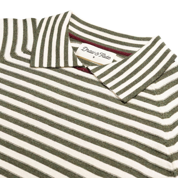 Folded green and white striped polo shirt with a brand label on a white background